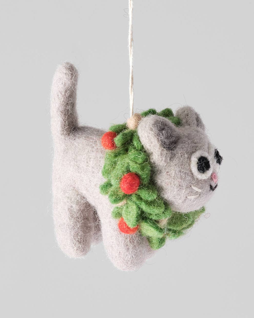 Gray cat-shaped ornament with a green wreath on a light gray background