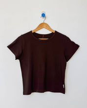 Brown t-shirt on a wooden hanger against a white background