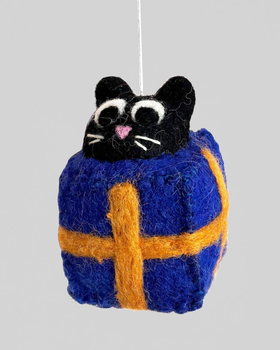 Cat-shaped ornament in a blue and orange checkered outfit on a gray background