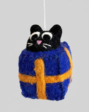 Cat-shaped ornament in a blue and orange checkered outfit on a gray background